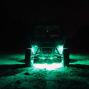 Image of off-road vehicle showcasing rock lights in green. The lights have swappable lens covers, allowing for customizable lighting in many colors.
