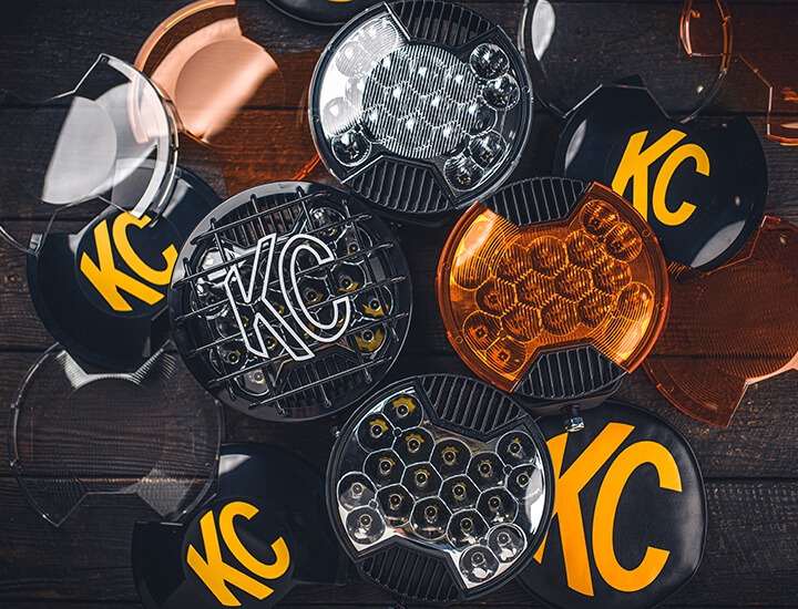 Tabletop shot of SlimLite 8" light surrounded by various shields, covers, and light accessories.